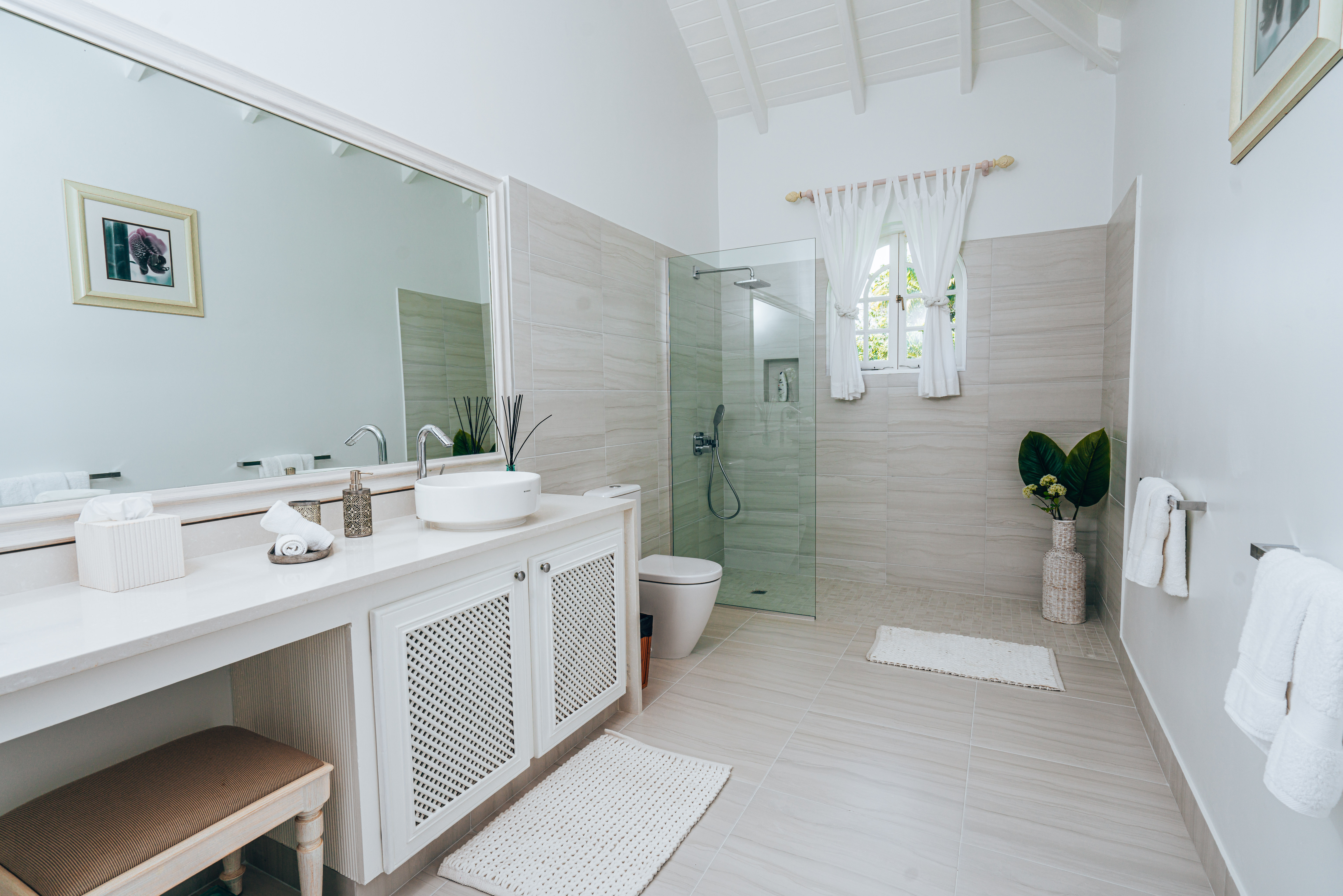 Large shower room with a high ceiling and a round wash basin above the white cupboard