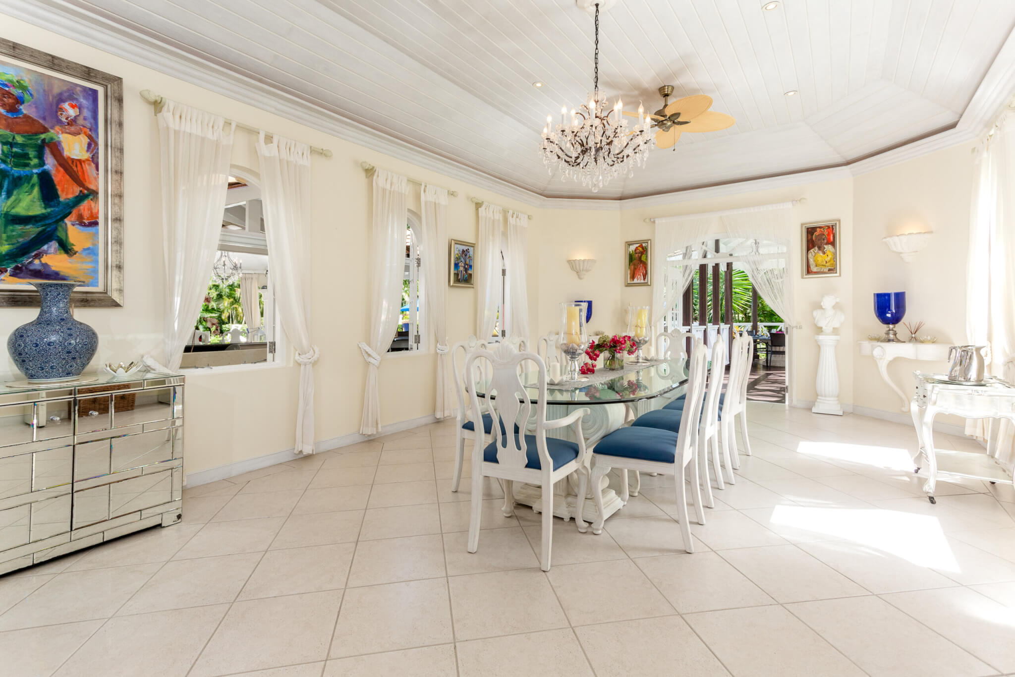 Large dining room with a very long glass dining table seating eight, with two large candles in the centre