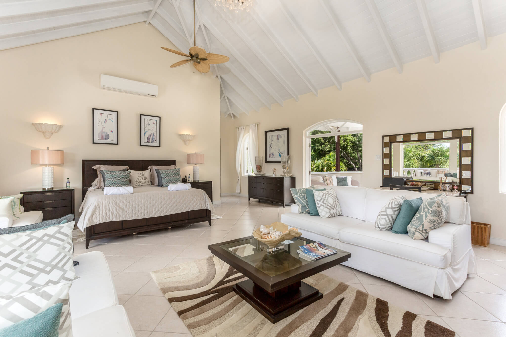 Master bedroom with high ceilings and a lounge area with two lounges and a coffee table